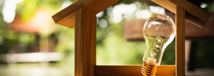 Light bulb with wood house on the table, a symbol for constructi